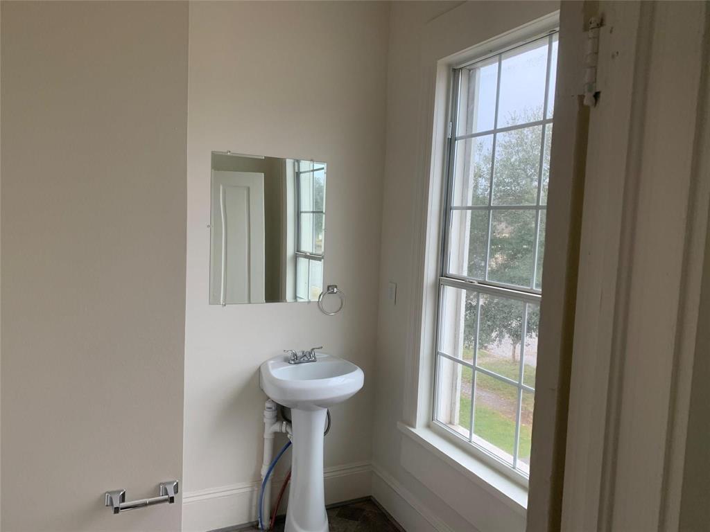 617 West Gandy Street, Unit 3 Denison, TX 75020 - Photo 12 of 14 a bathroom with a sink window and a mirror