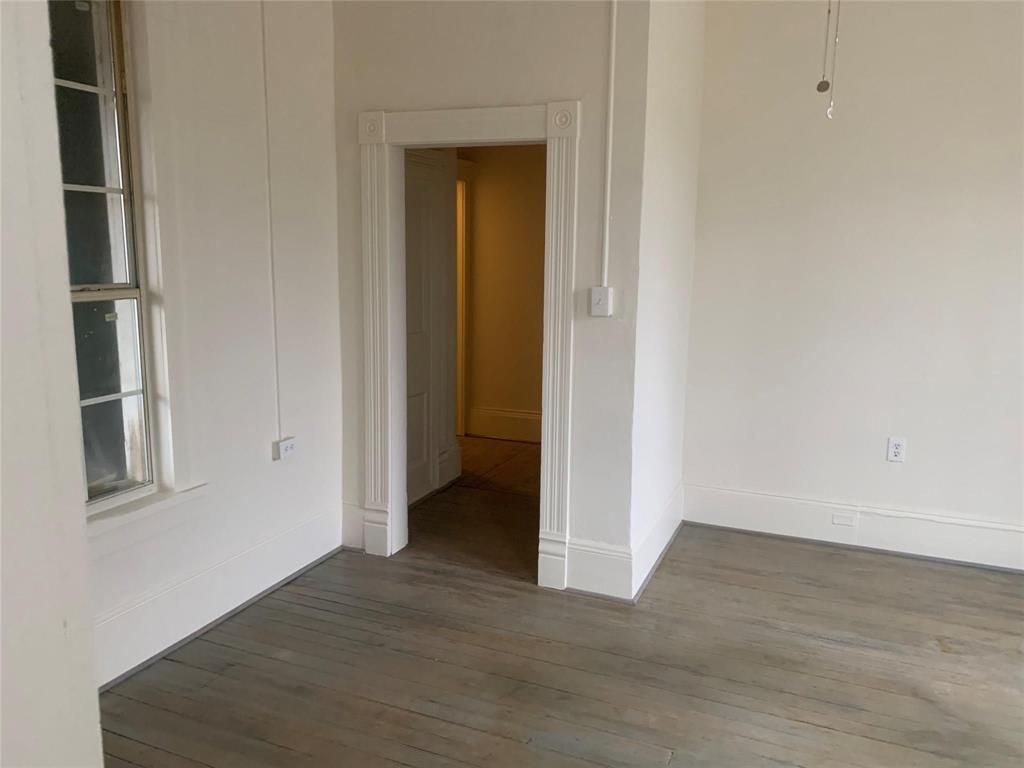 617 West Gandy Street, Unit 3 Denison, TX 75020 - Photo 3 of 14 a view of an empty room with wooden floor and closet