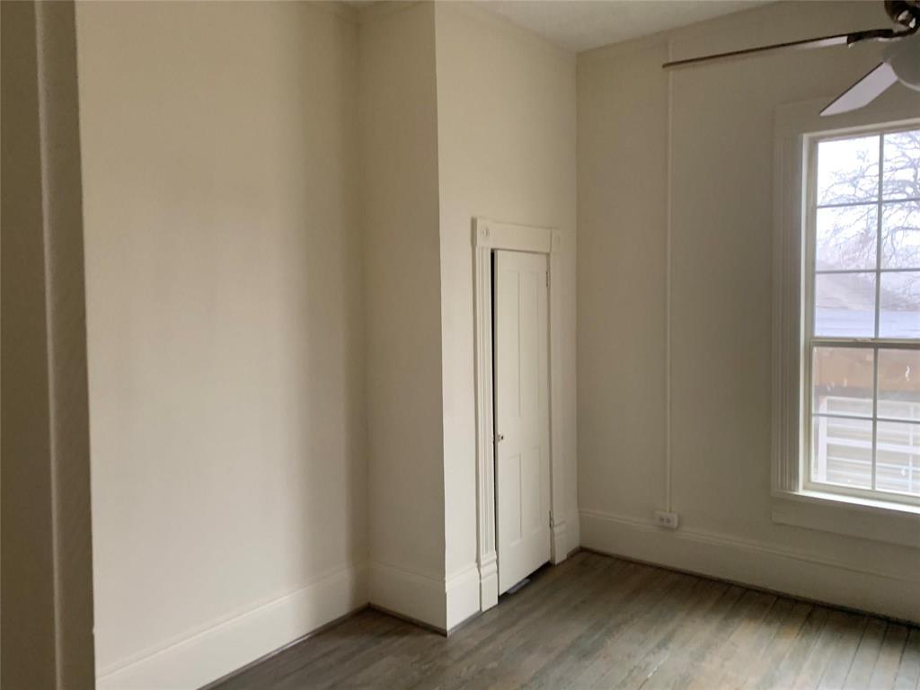 617 West Gandy Street, Unit 3 Denison, TX 75020 - Photo 6 of 14 an empty room with wooden floor and windows