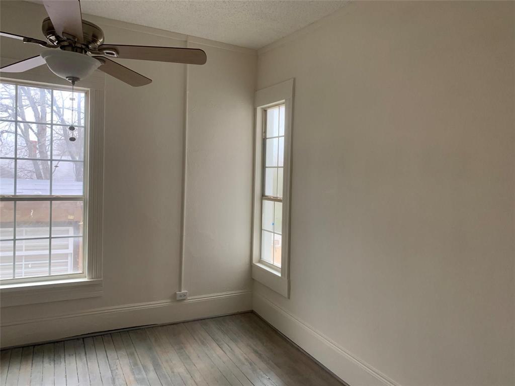 617 West Gandy Street, Unit 3 Denison, TX 75020 - Photo 7 of 14 a view of empty room with wooden floor and fan