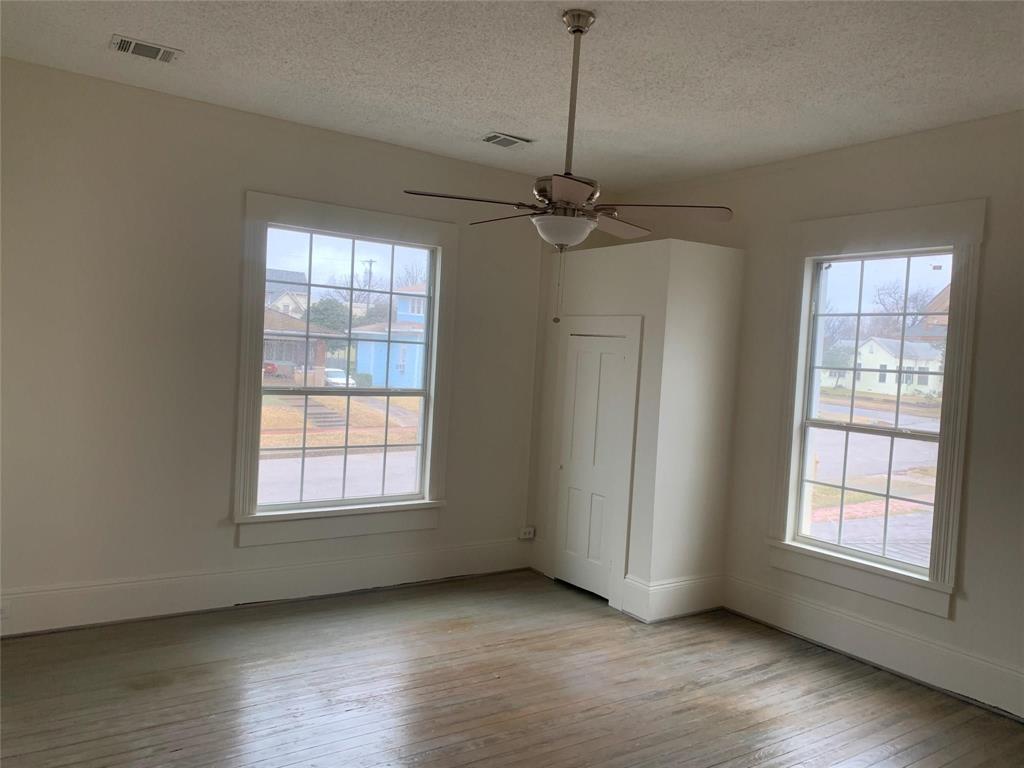 617 West Gandy Street, Unit 3 Denison, TX 75020 - Photo 8 of 14 a view of an empty room with wooden floor cabinet and a window