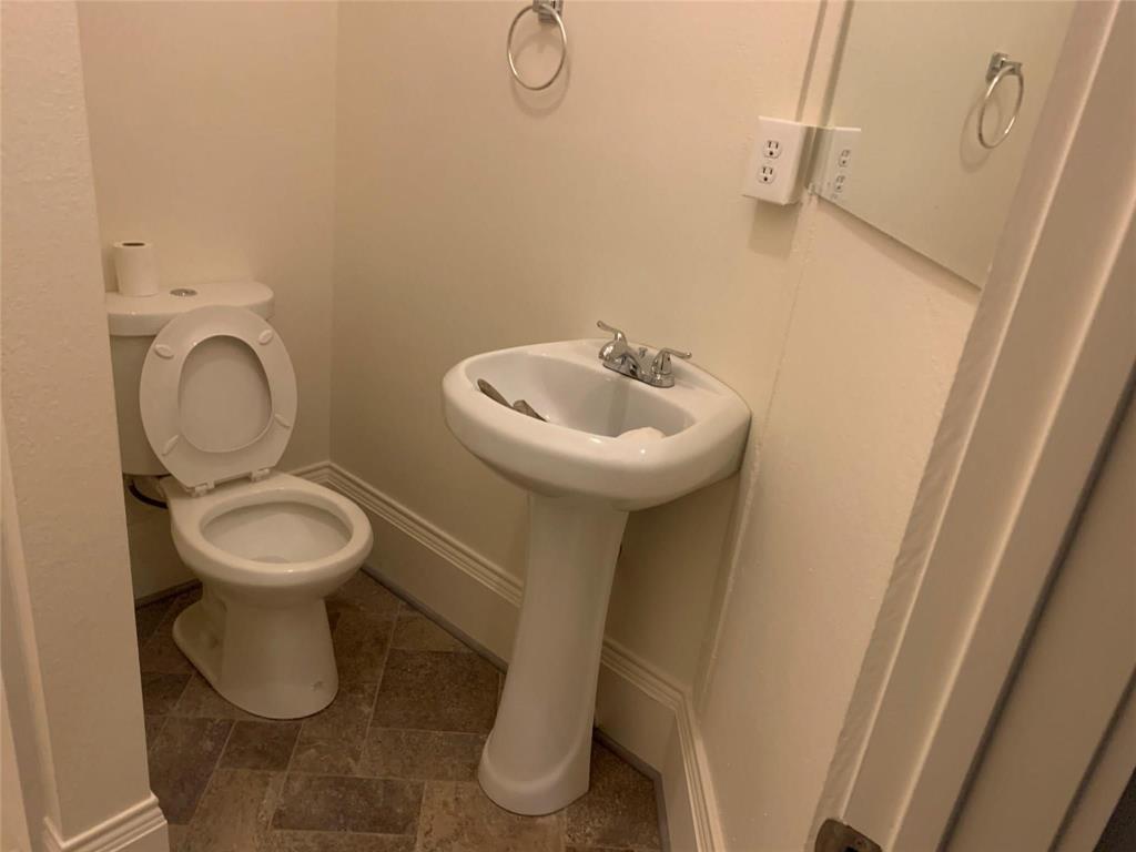 617 West Gandy Street, Unit 3 Denison, TX 75020 - Photo 10 of 14 a bathroom with a toilet sink and mirror