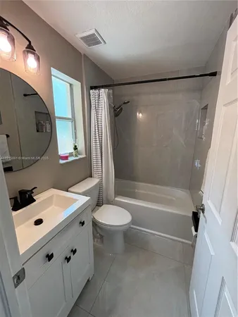 a bathroom with a bathtub sink vanity mirror and toilet