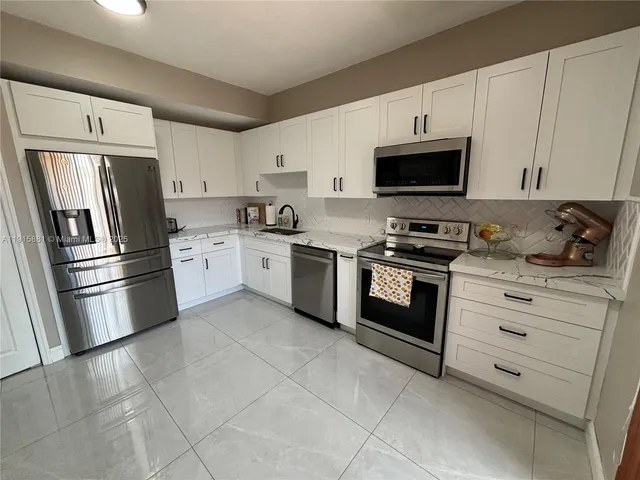 a kitchen with cabinets stainless steel appliances and a counter space