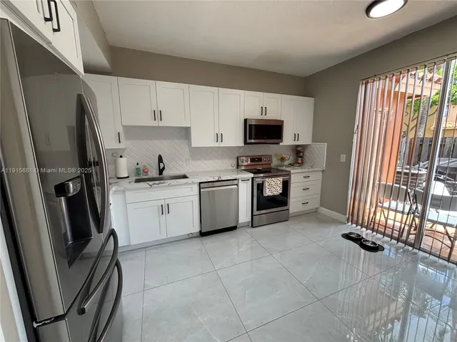 a kitchen with stainless steel appliances a refrigerator sink and microwave