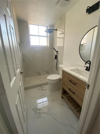 a bathroom with a sink mirror vanity and toilet