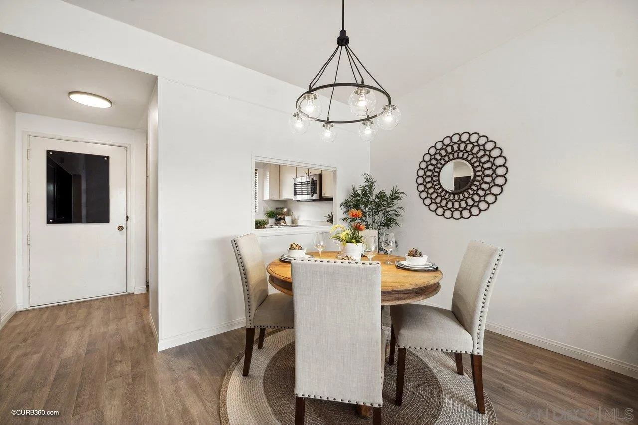 12218 Rancho Bernardo Road, Unit B San Diego, CA 92128 - Photo 15 of 30 a dining room with wooden floor a chandelier a wooden table and chairs