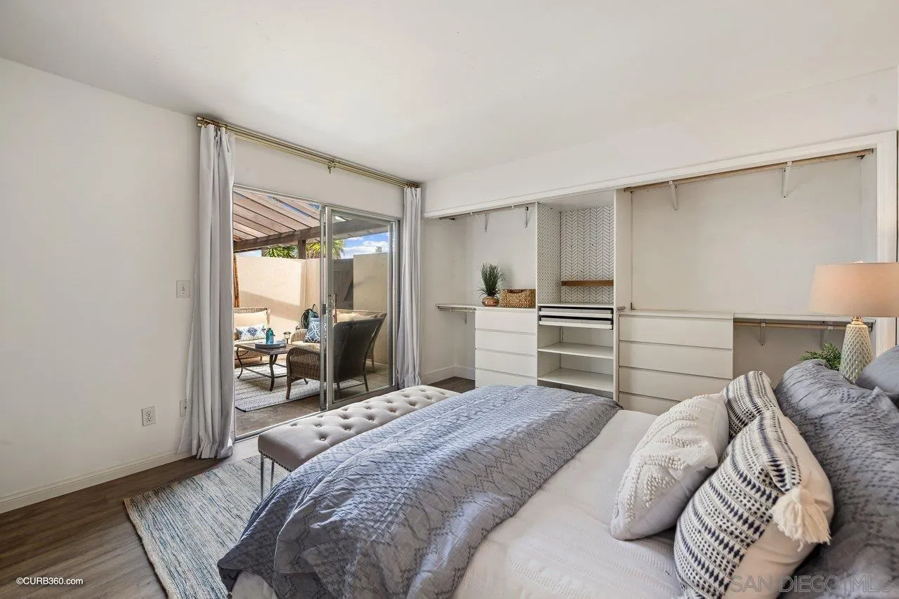 12218 Rancho Bernardo Road, Unit B San Diego, CA 92128 - Photo 25 of 30 a bedroom with a bed and a large mirror