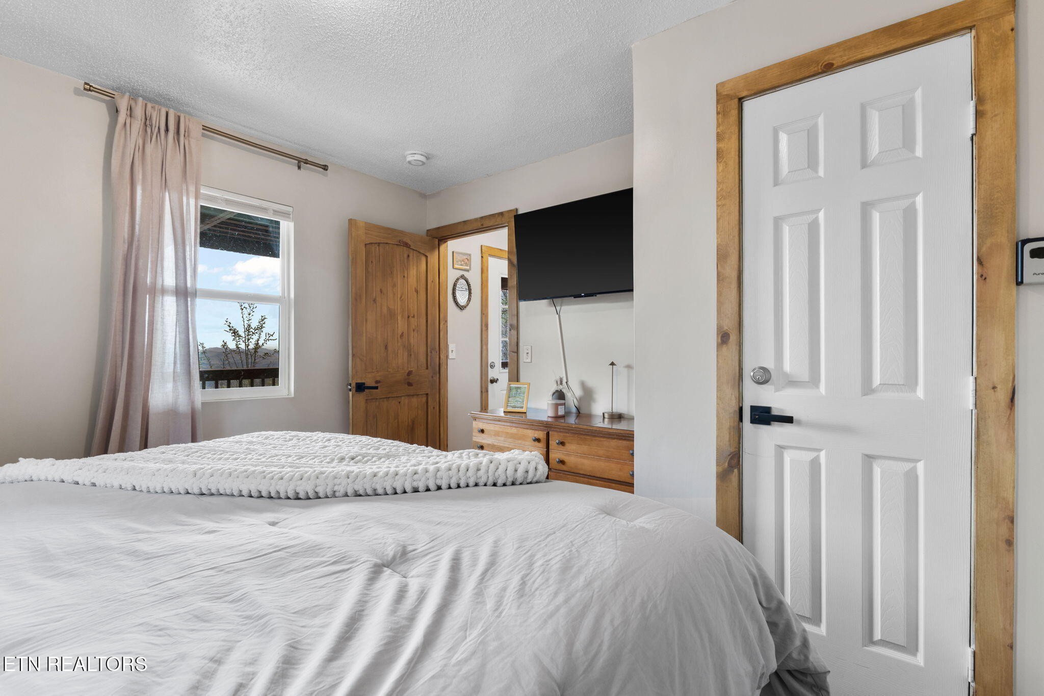 1115 Red Maple Lane Sevierville, TN 37876 - Photo 36 of 55 a bedroom with a bed a flat screen tv and a window