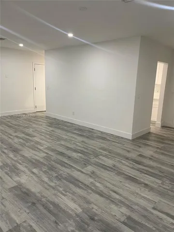 an empty room with wooden floor and window