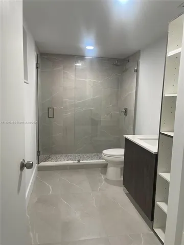 a bathroom with a toilet and a shower