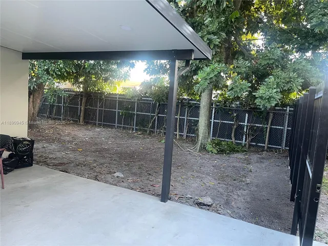 a backyard of a house with plants and wooden fence