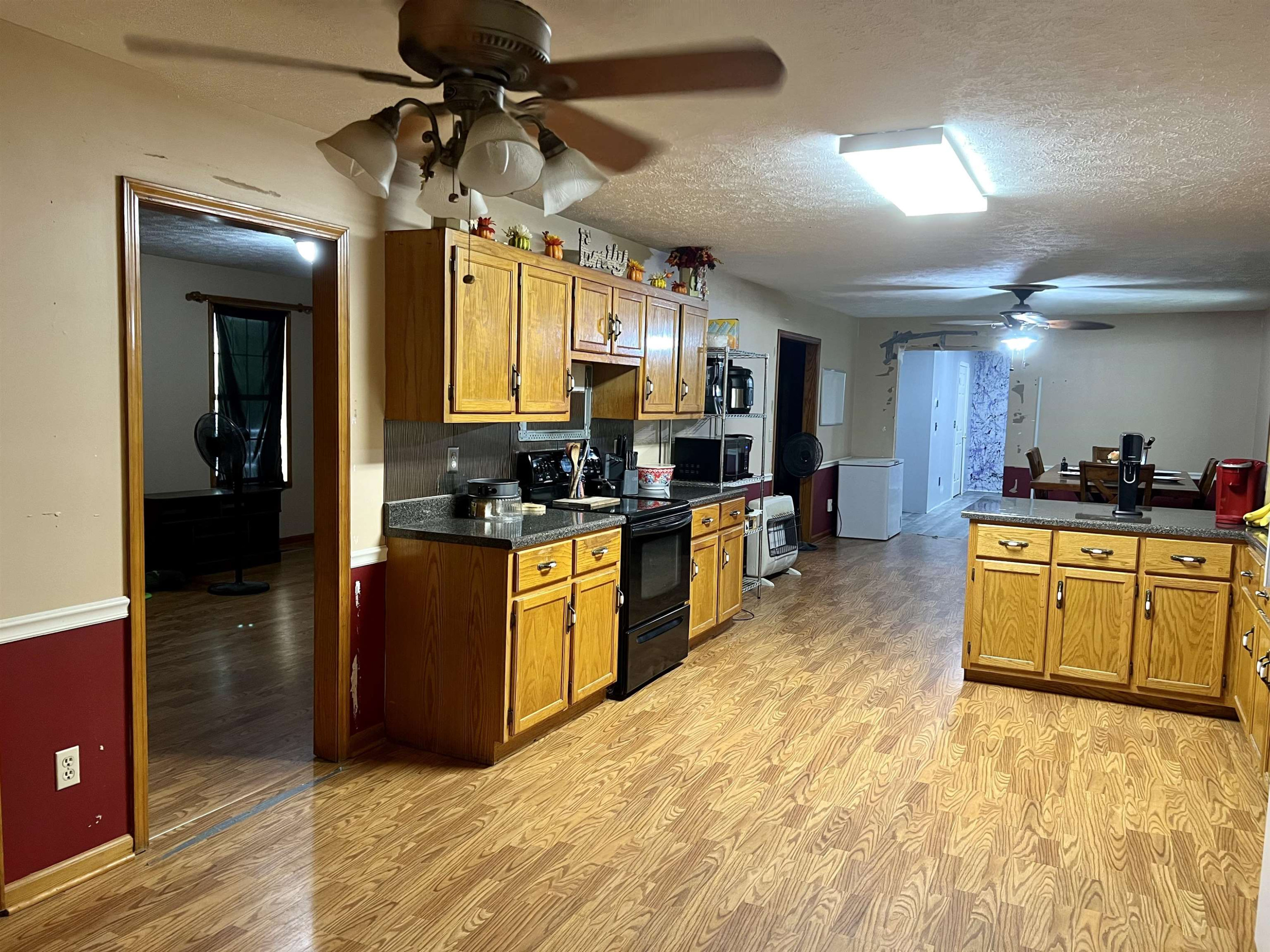 6100 Enville Road Henderson, TN 38340 - Photo 11 of 25 a kitchen with stainless steel appliances kitchen island granite countertop a stove top oven a sink a counter space and cabinets
