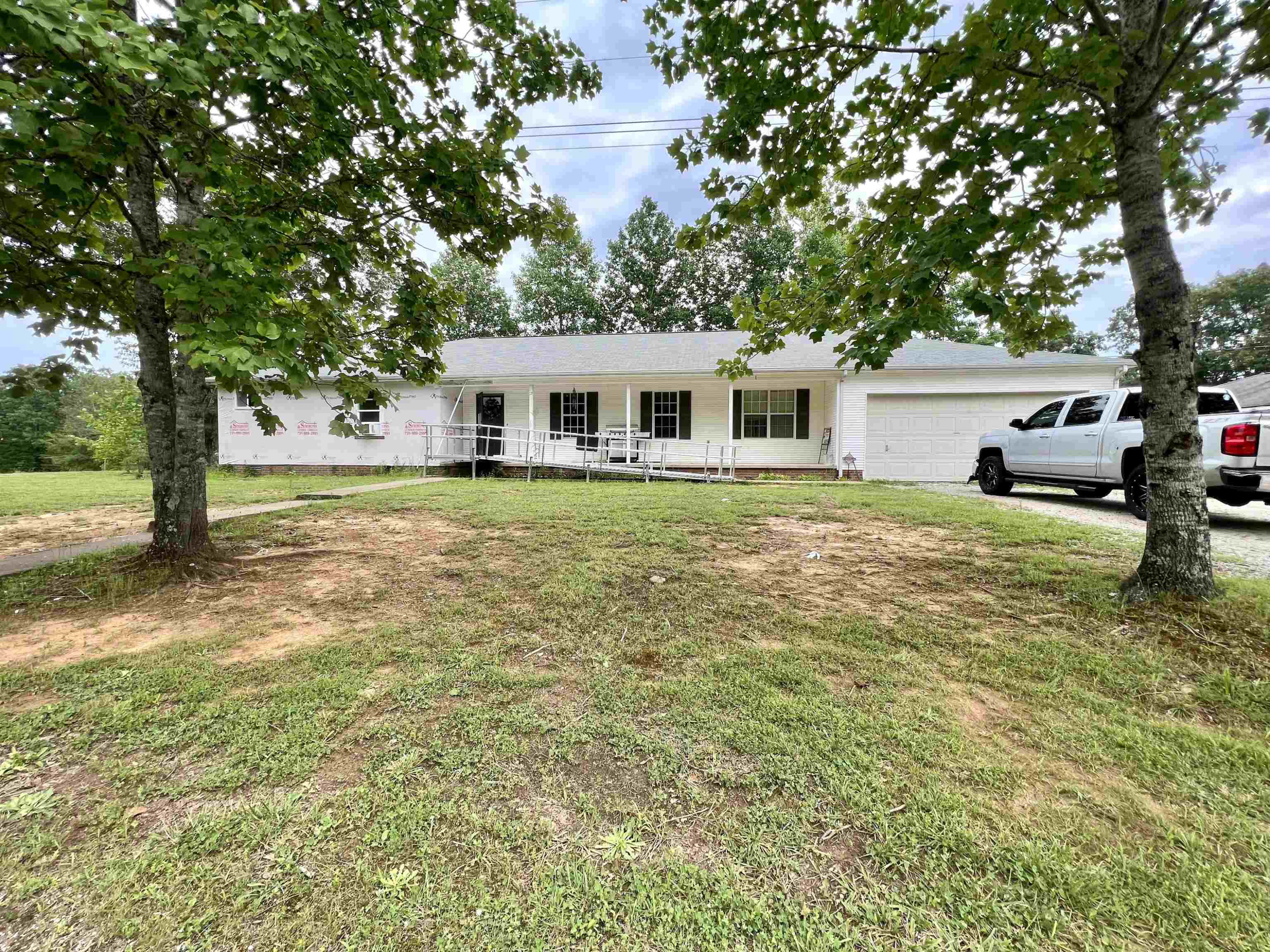6100 Enville Road Henderson, TN 38340 - Photo 3 of 25 a white house that has a tree in front of it