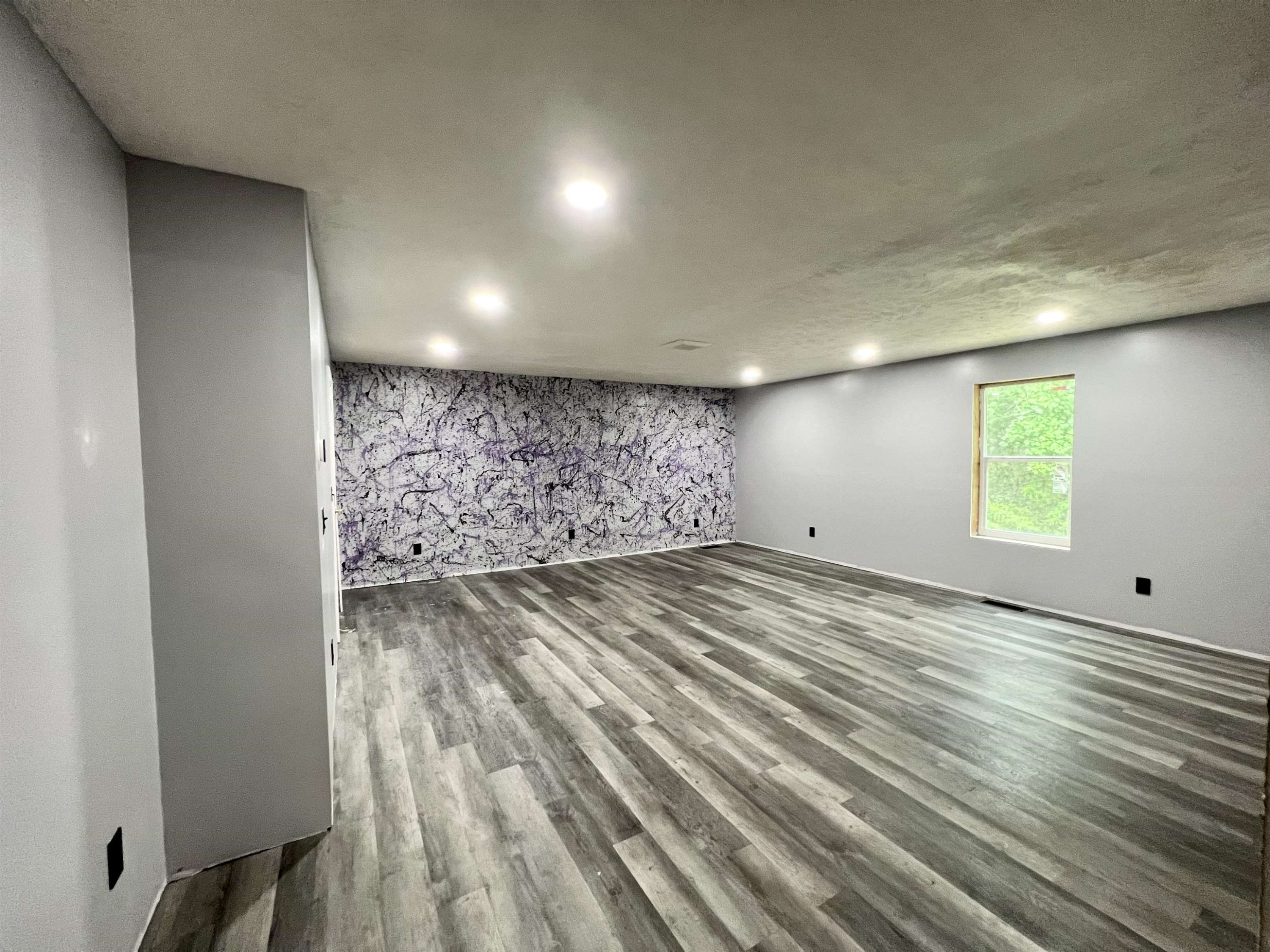 6100 Enville Road Henderson, TN 38340 - Photo 4 of 25 an empty room with wooden floor and windows