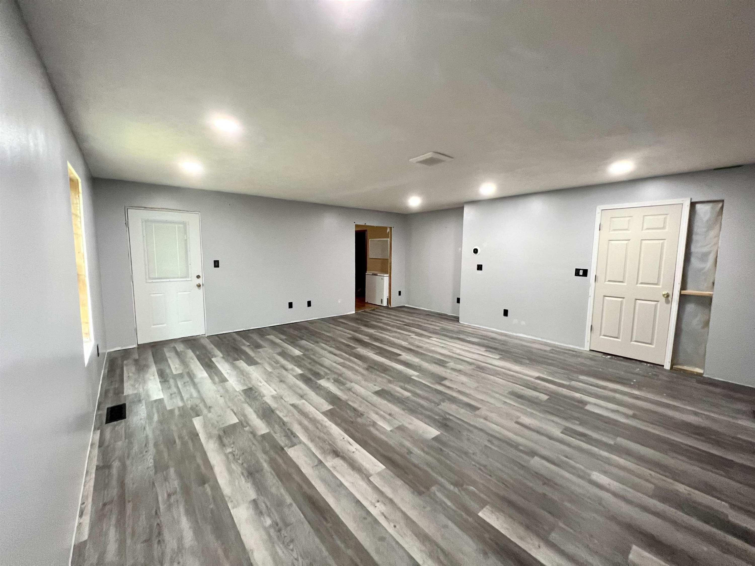 6100 Enville Road Henderson, TN 38340 - Photo 5 of 25 an empty room with wooden floor and windows
