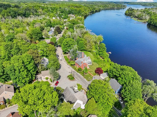 an aerial view of a house with a yard and lake view