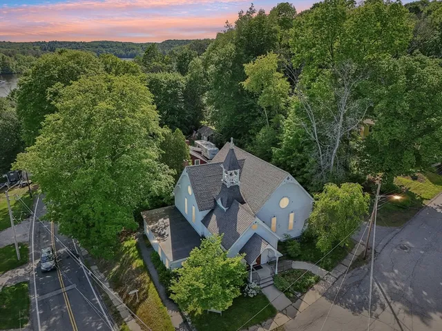 an aerial view of a house with a yard and mountain view in back