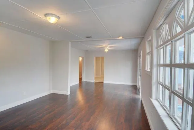 wooden floor in an empty room with a window