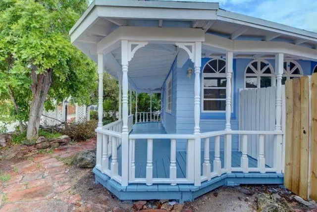 a view of wooden house with a small yard
