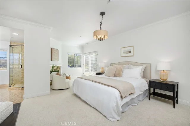 a spacious bedroom with a bed and a chandelier