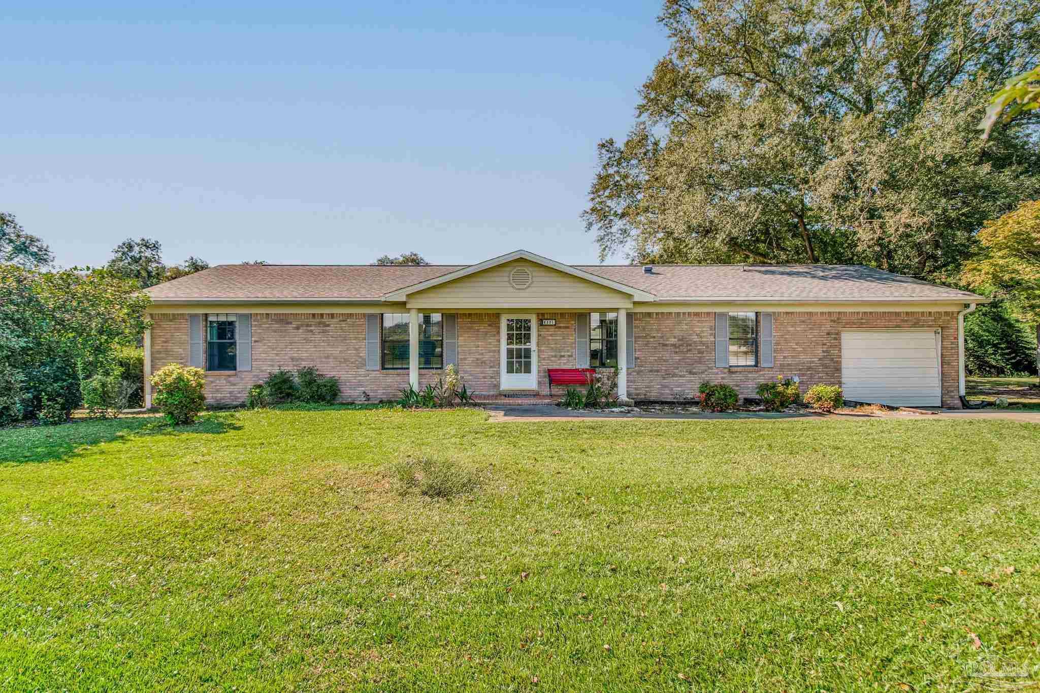 6201 Meadows Road Walnut Hill, FL 32568 - Photo 1 of 50 a front view of a house with a garden