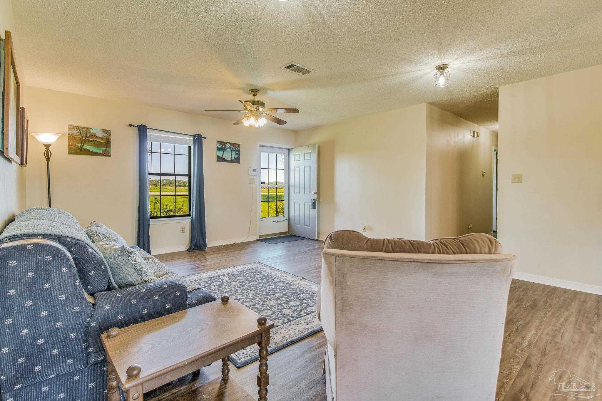 6201 Meadows Road Walnut Hill, FL 32568 - Photo 24 of 50 a living room with furniture and wooden floor
