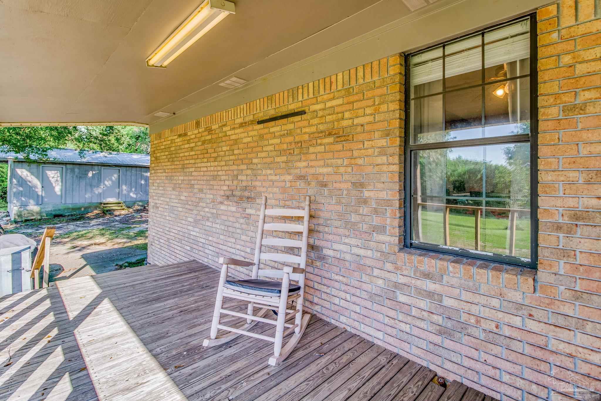 6201 Meadows Road Walnut Hill, FL 32568 - Photo 10 of 50 a view of a porch with furniture and garden
