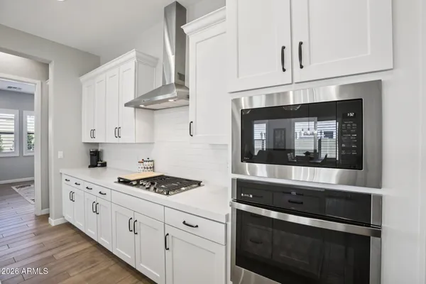 a kitchen with stainless steel appliances granite countertop a dining table chairs refrigerator and microwave