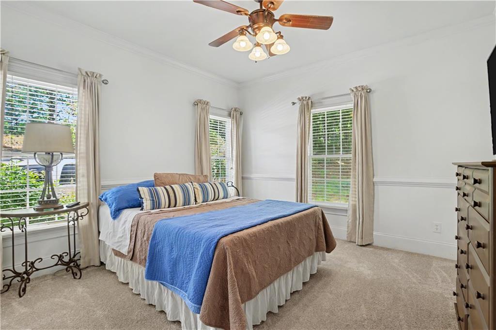 537 Old Collins Road Hoschton, GA 30548 - Photo 25 of 42 a bedroom with a bed a chandelier and a window