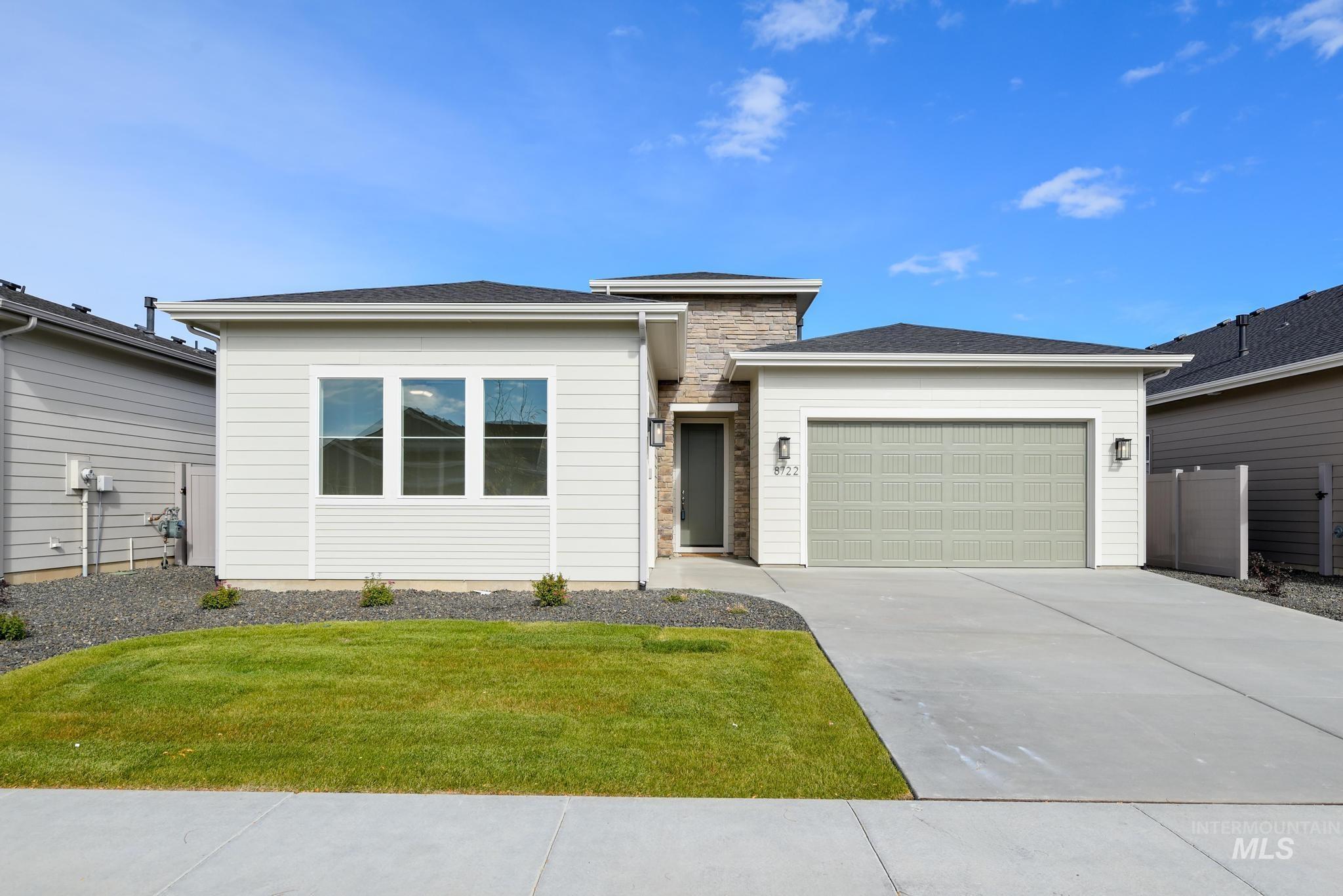 Prairie-style home with driveway, an attached garage, a front lawn, and a shingled roof