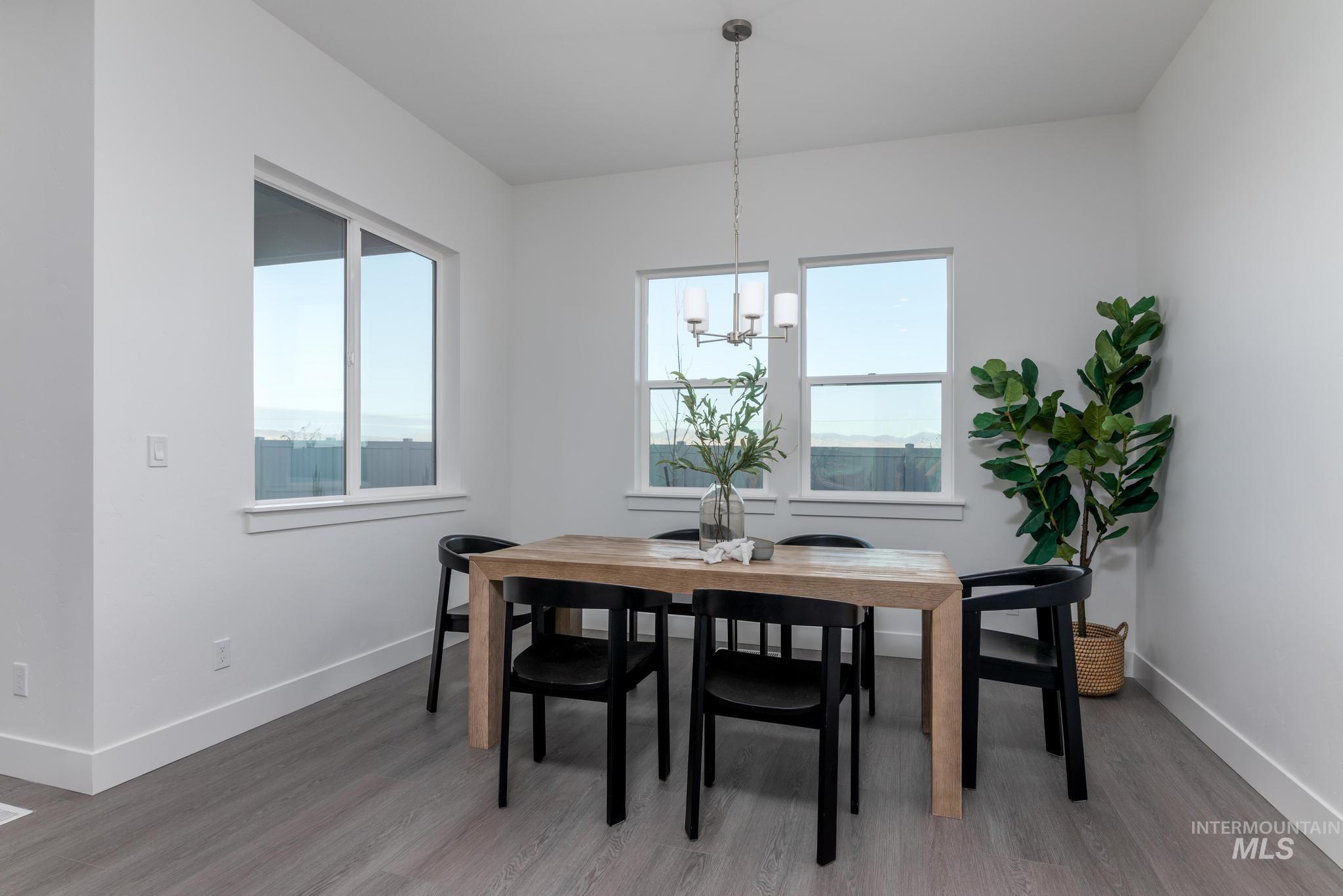 8520 West Fanning Street Star, ID 83669 - Photo 6 of 11 Dining room with healthy amount of natural light, wood finished floors, and a chandelier
