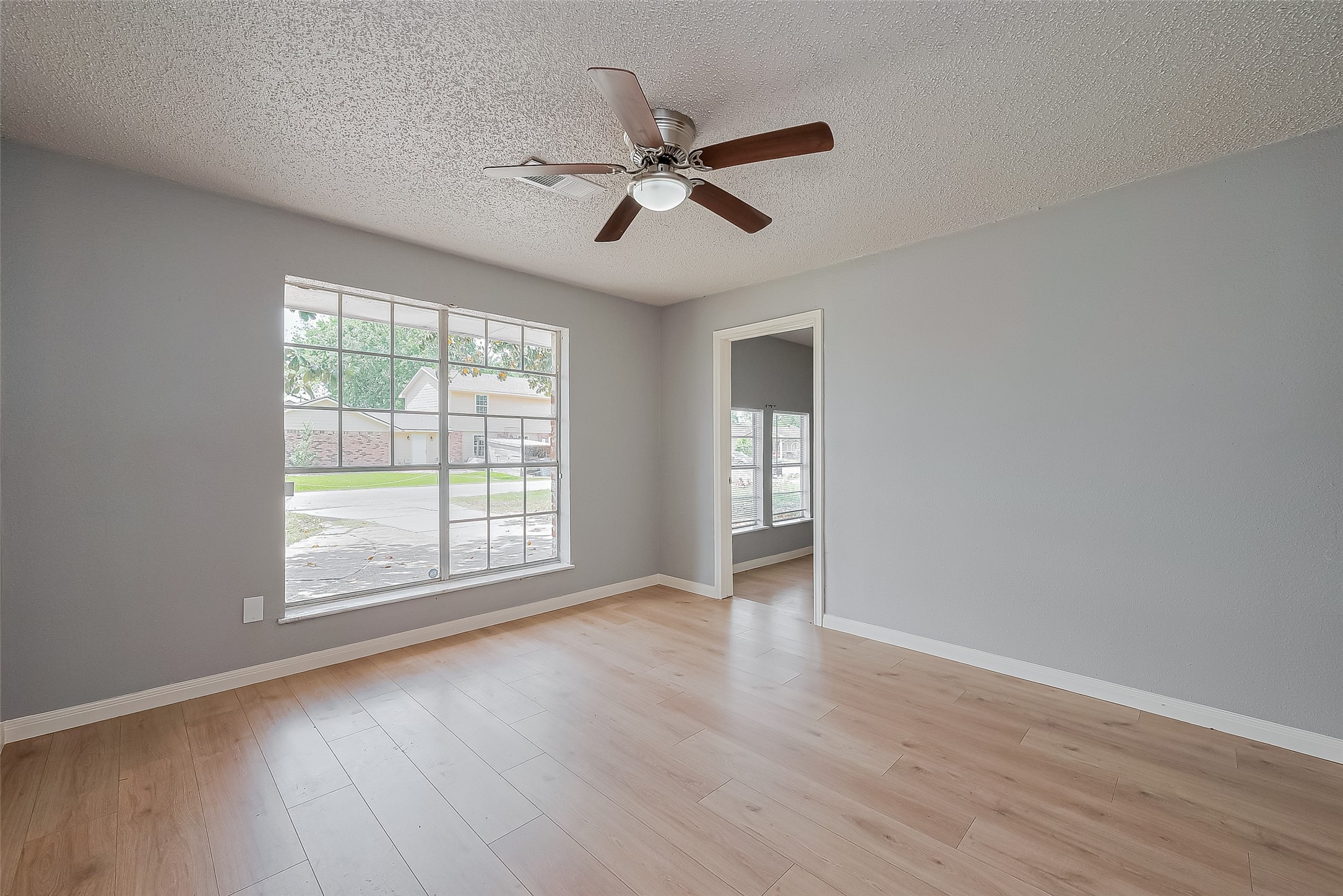206 Beaver Bend Road Houston, TX 77037 - Photo 11 of 38 an empty room with wooden floor fan and windows
