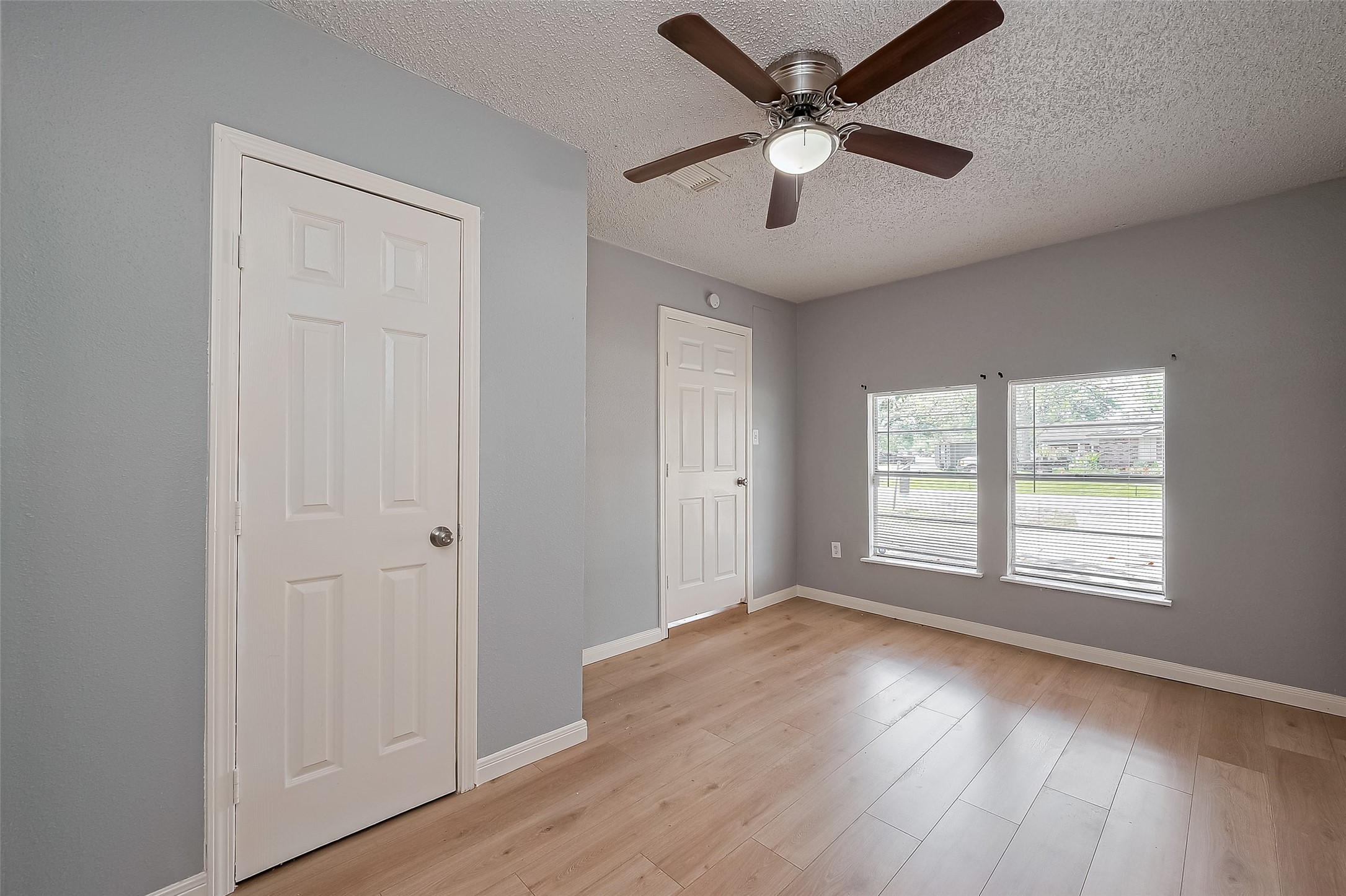 206 Beaver Bend Road Houston, TX 77037 - Photo 24 of 38 an empty room with wooden floor chandelier fan and windows