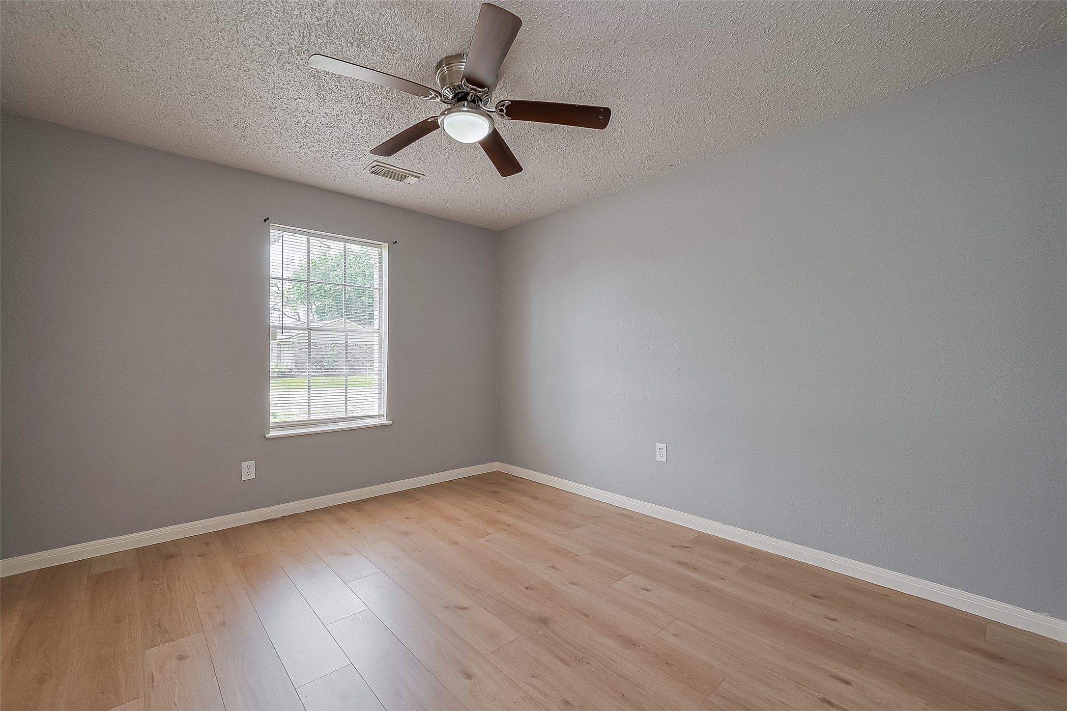 206 Beaver Bend Road Houston, TX 77037 - Photo 25 of 38 an empty room with wooden floor fan and windows