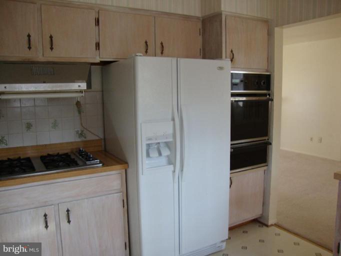 5236 Inverchapel Road Springfield, VA 22151 - Photo 4 of 7 a white refrigerator freezer and a stove sitting inside of a kitchen