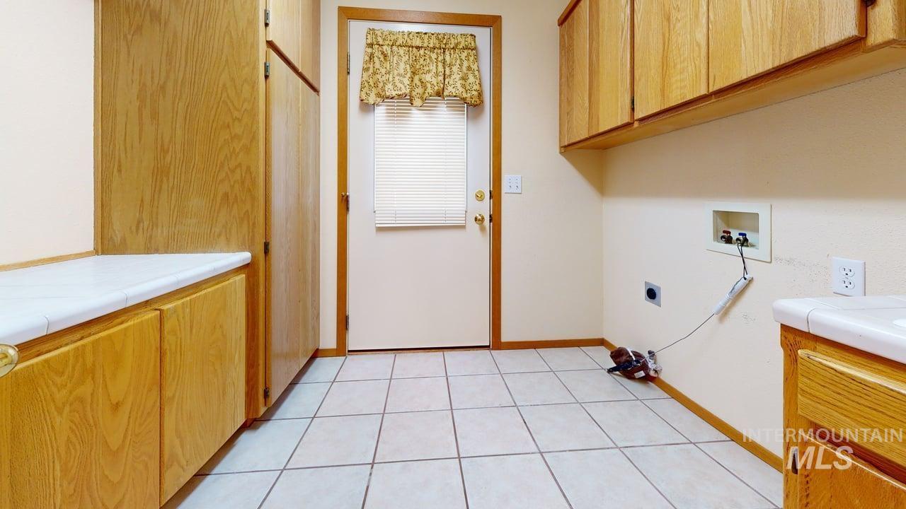 2794 9th Avenue Clarkston, WA 99403 - Photo 27 of 34 Laundry room with cabinet space, hookup for a washing machine, electric dryer hookup, and light tile patterned floors
