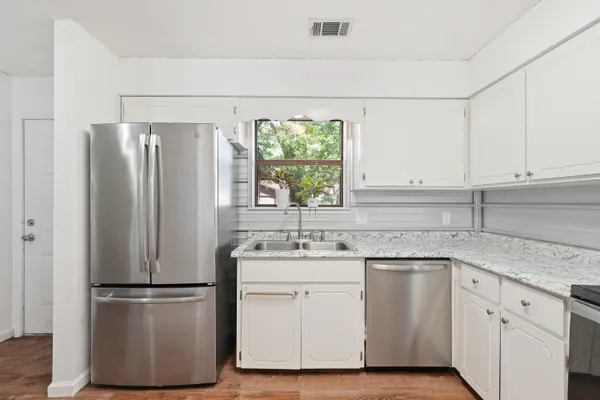 a kitchen with a refrigerator sink and cabinets