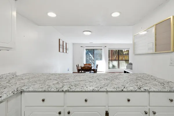 a kitchen with granite countertop a sink and white cabinets