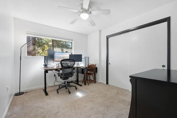 a view of a workspace with furniture and a window