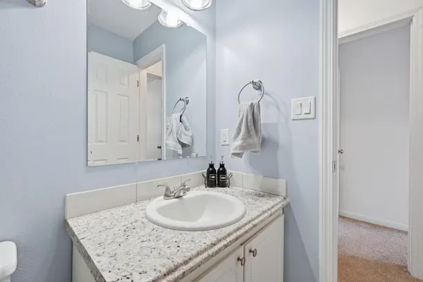 a bathroom with a granite countertop sink and a mirror