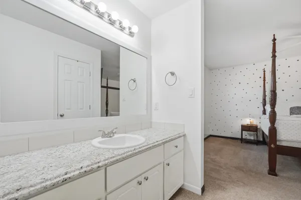 a bathroom with a granite countertop sink and a mirror