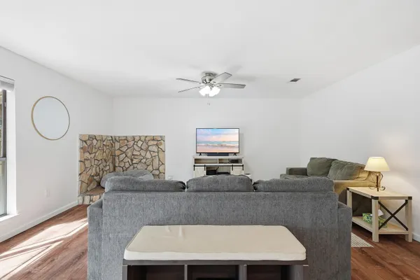 a living room with furniture a chandelier fan and a window