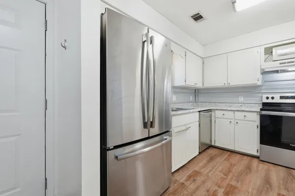 a kitchen with a refrigerator sink and cabinets
