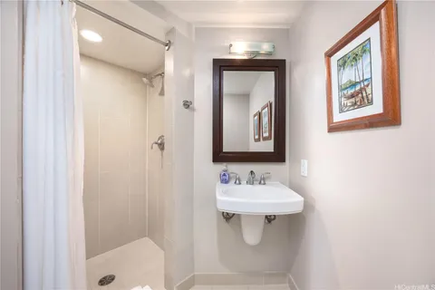 a bathroom with a sink mirror and shower