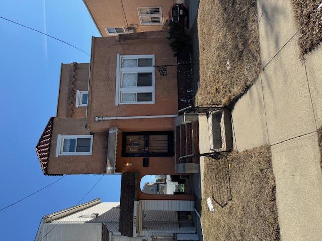 View of front of property featuring entry steps, a tiled roof, and stucco siding