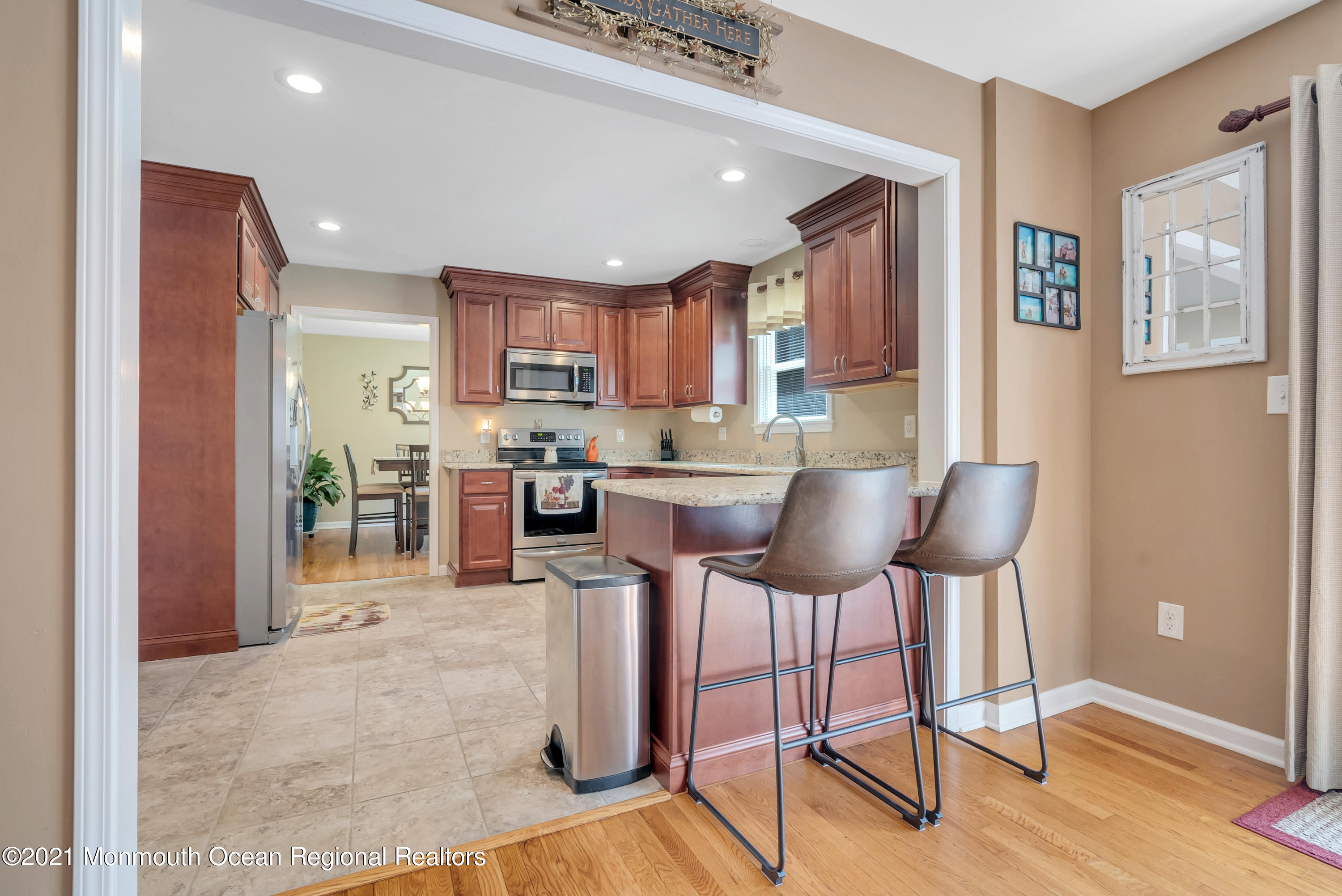 93 Jackson Mills Road Jackson, NJ 08527 - Photo 15 of 39 a kitchen with stainless steel appliances granite countertop a stove top oven a sink dishwasher a dining table and chairs with wooden floor
