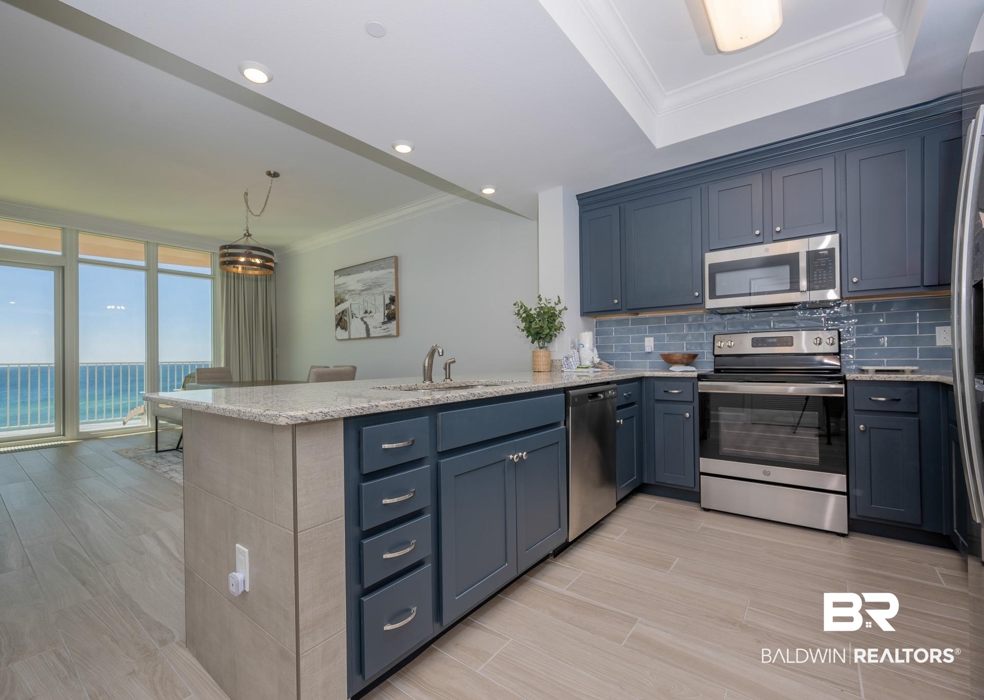 23008 Perdido Beach Boulevard, Unit 506 Orange Beach, AL 36561 - Photo 3 of 48 Kitchen featuring appliances with stainless steel finishes, a sink, light stone counters, a peninsula, and ornamental molding