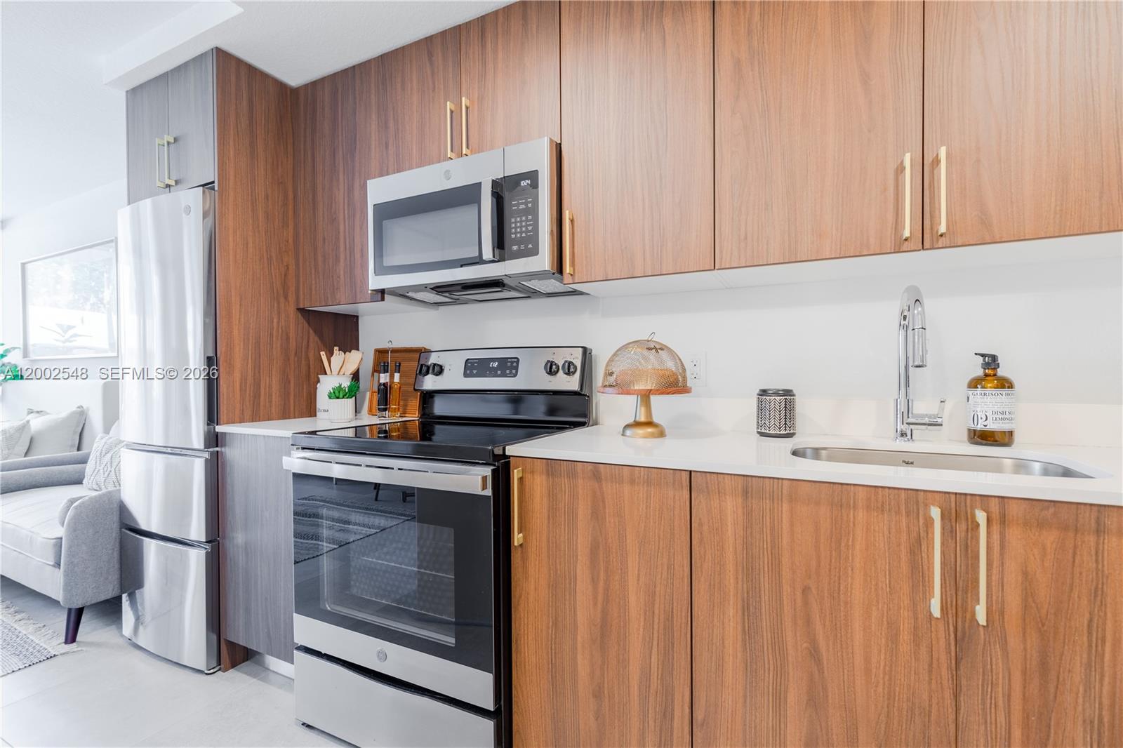 1950 West 49th Street, Unit 373 Hialeah, FL 33012 - Photo 9 of 30 a kitchen with stainless steel appliances a stove microwave and sink