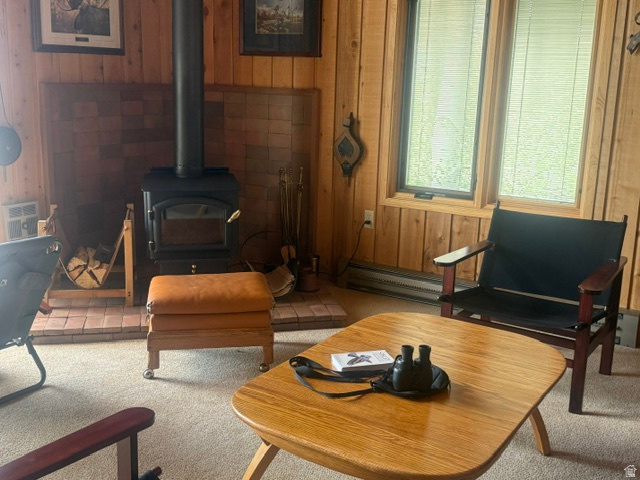 12592 Lupine Ridge Road Salt Lake City, UT 84121 - Photo 3 of 20 Wood-paneled room featuring a black wood-burning stove on a brick hearth, bordered by a tiled wall